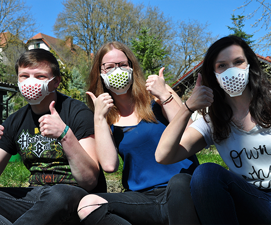 3 Jugendliche mit Daumen Hoch und Mund-Nasenschutz-Maske